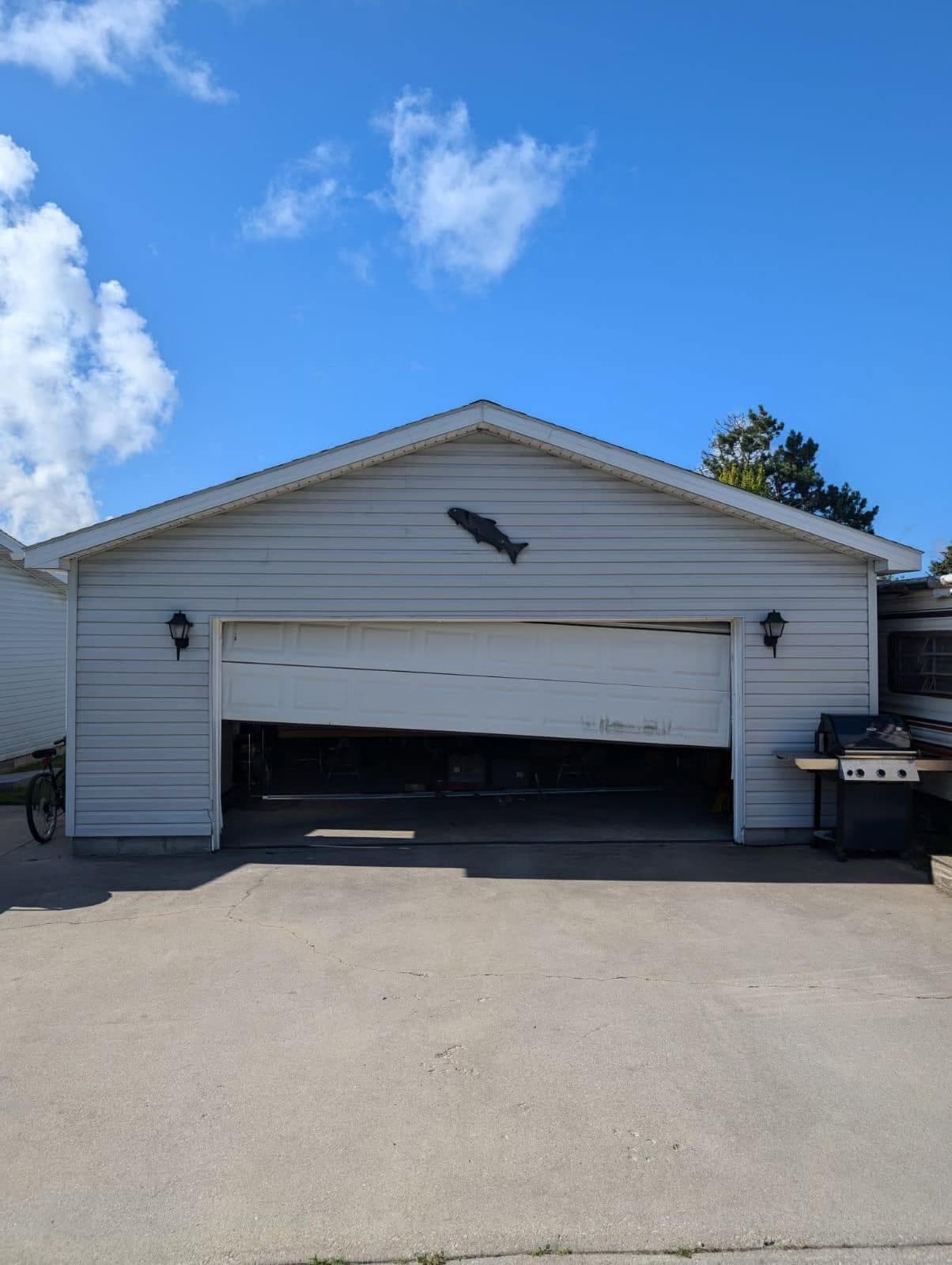 Garage door hanging crooked after coming off its track